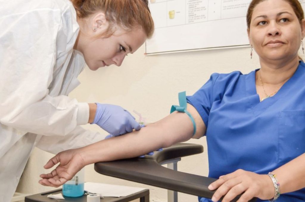 A phlebotomist student practicing a blood draw on peer.