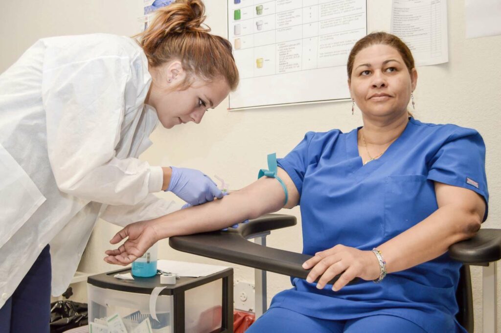 A new phlebotomist in California practices blood draws.
