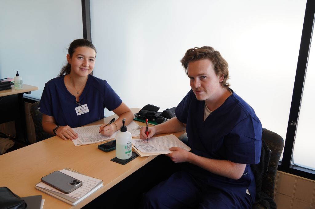 Students from CALRegional practice medical assistant duties such as charting a patient's medical history.