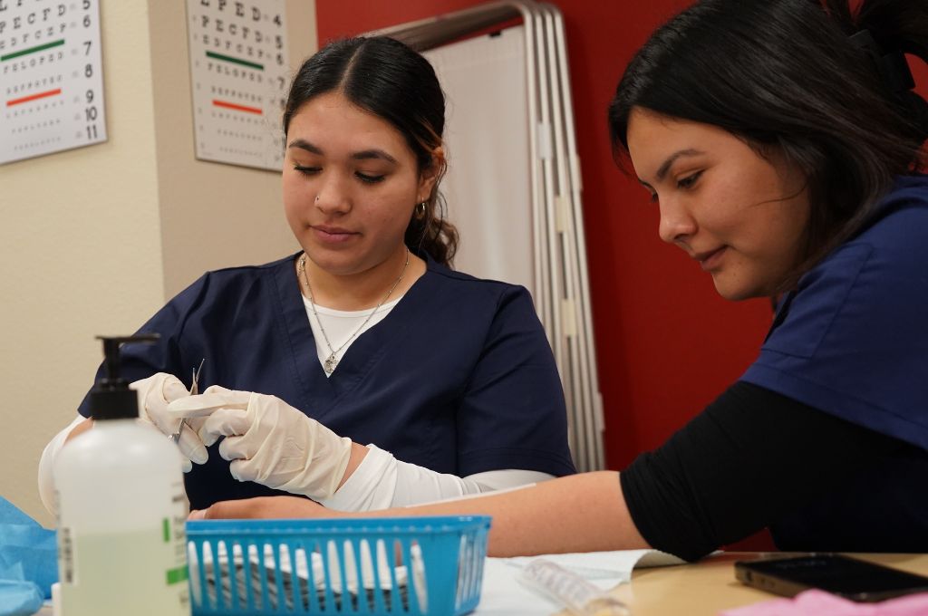 Future Certified Medical Assistants practice hands-on training in class.