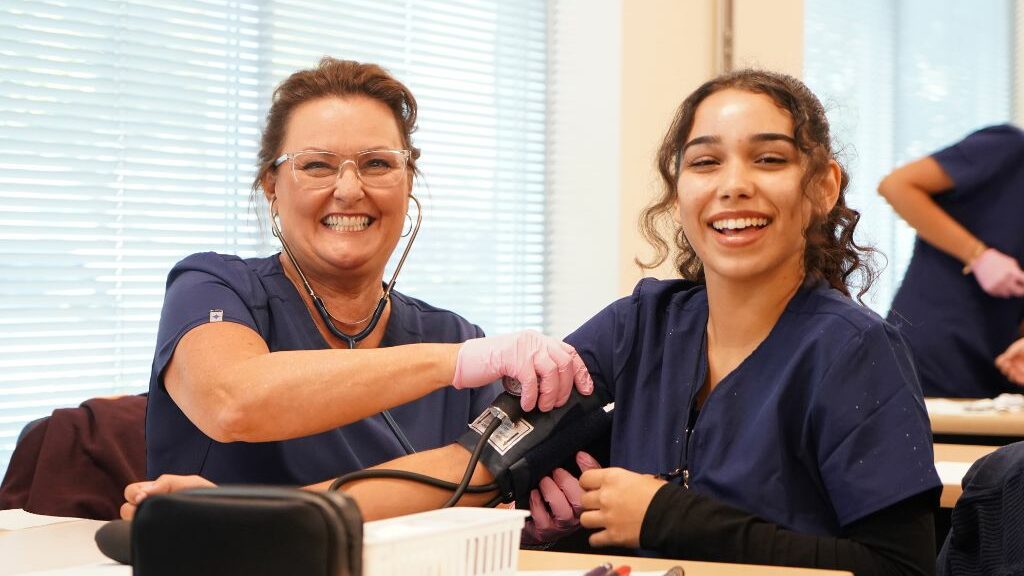 Medical assistant school students practice taking vitals.