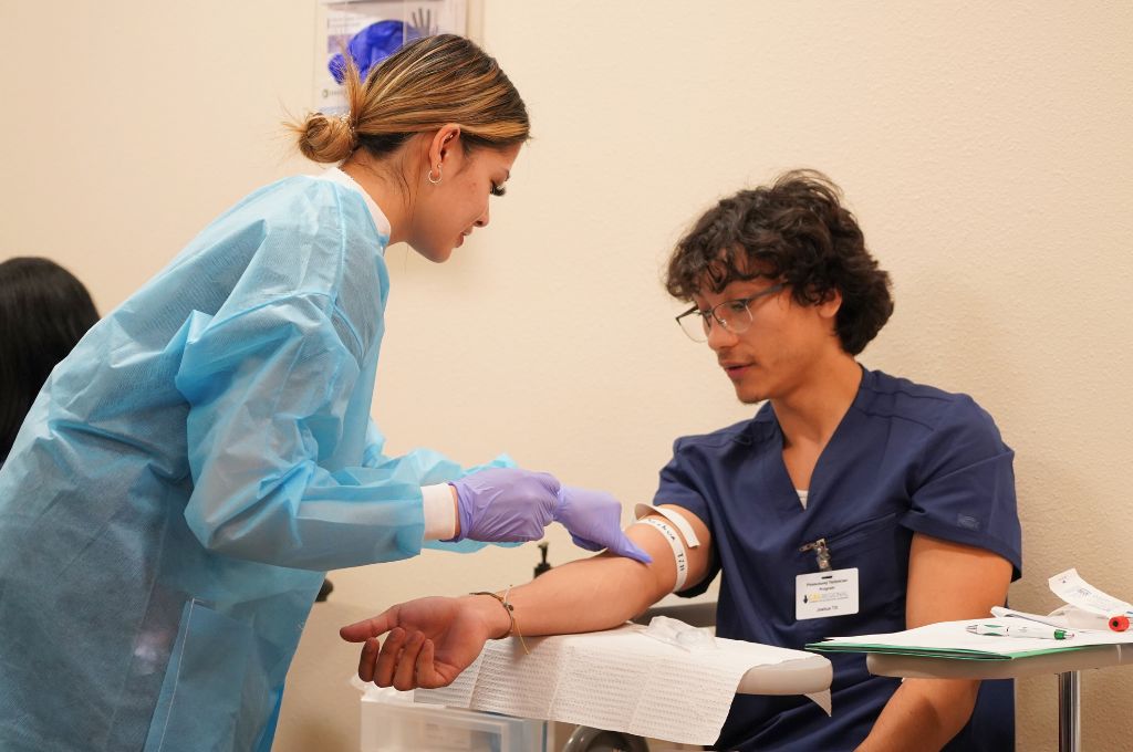 A patient care technician practices phlebotomy. 