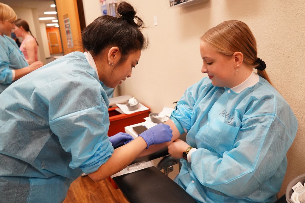 Phlebotomy student practicing a blood draw during hands-on training in a California phlebotomy program