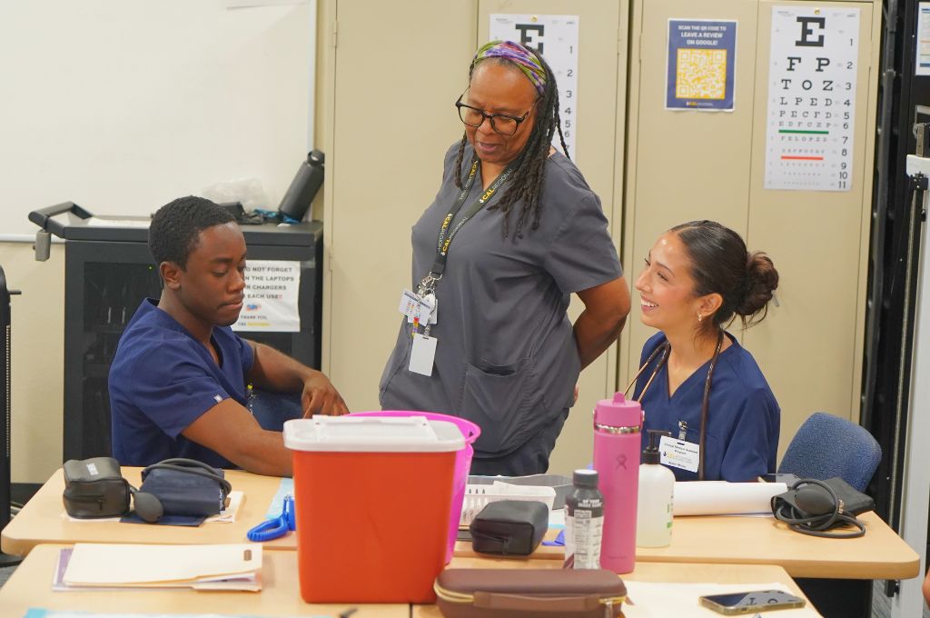 Medical assistant instructor guiding students during hands-on classroom training