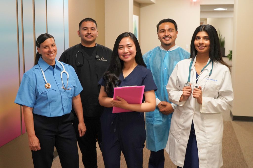 Group of CALRegional-trained healthcare professionals in EMT, medical assistant, and clinical lab uniforms standing together